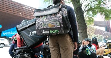 App-based delivery workers wait outside of a restaurant that uses app deliveries