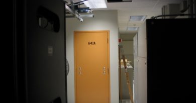 a photo of the exterior of Room 641A, which has a yellow door without a door handle, in a dimly lit datacenter in a San Francisco AT&T hub.
