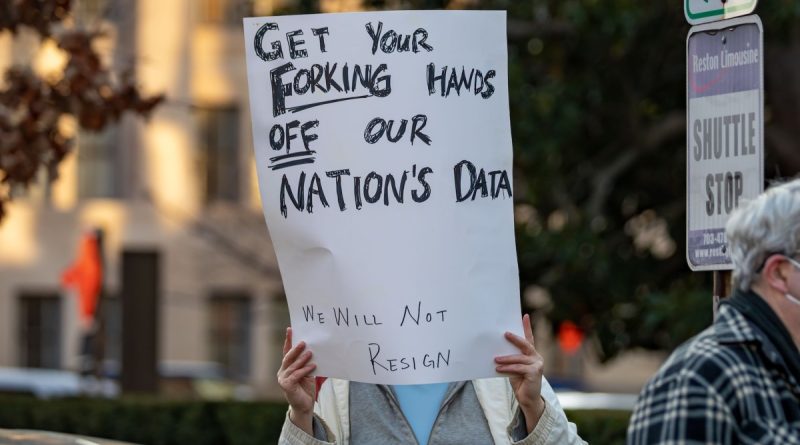 a photo of a protesters in Washington DC with a sign that says "GET YOUR FORKING HANDS OFF OUR NATION'S DATA"