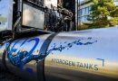 A hydrogen tank sits attached to an idle semi truck.