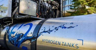 A hydrogen tank sits attached to an idle semi truck.