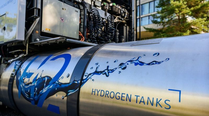 A hydrogen tank sits attached to an idle semi truck.