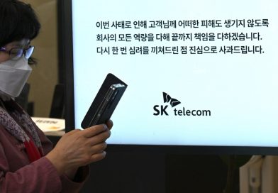 A woman uses her mobile phone while waiting to replace her USIM ship in front of an SK Telecom branch in Seoul on April 28, 2025.